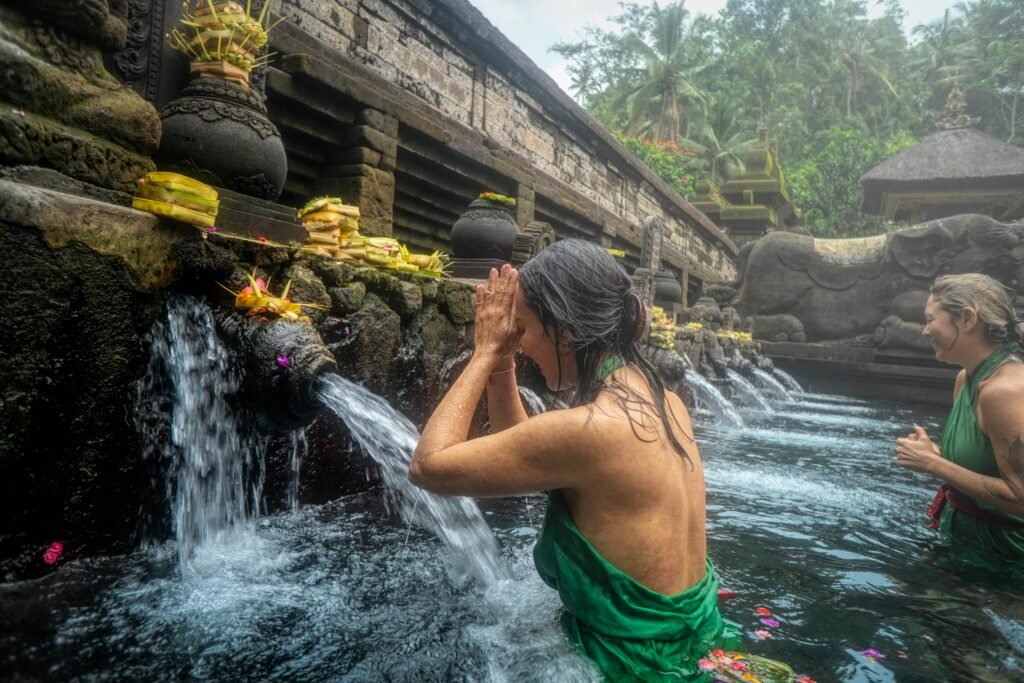 Women participating in a sacred water purification ritual at Pura Tirta Empul Temple in Bali, Indonesia.